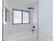 Renovated bathroom showcases white marble tile, bathtub and a sleek black showerhead at 2405 Pickwick Dr # 55, Henderson, NV 89014