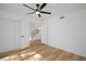 Bright bedroom with wood floors, modern ceiling fan and access to stairs through double doors, creating a spacious and airy feel at 2405 Pickwick Dr # 55, Henderson, NV 89014
