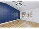 Bedroom features wood floors, navy wainscoting accent wall, ceiling fan, and bright window at 2405 Pickwick Dr # 55, Henderson, NV 89014