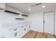 Kitchen area with white cabinets, marble counters, and black floating shelves at 2405 Pickwick Dr # 55, Henderson, NV 89014