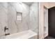 Bright bathroom featuring white marble tile, a modern bathtub, and sleek fixtures at 250 Shadybrook Ln # D, Las Vegas, NV 89107