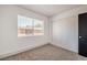 Bright bedroom featuring neutral carpet, closet, and a window letting in natural light at 250 Shadybrook Ln # D, Las Vegas, NV 89107