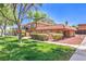 Charming two-story condo featuring a red tile roof, well-maintained landscaping and a lush green lawn at 250 Shadybrook Ln # D, Las Vegas, NV 89107