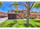 Two-story condo building with personal garages, well-kept lawn, and red tile roof at 250 Shadybrook Ln # D, Las Vegas, NV 89107