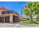 Two-story building with private garages and outdoor staircase, set amongst lush green lawns at 250 Shadybrook Ln # D, Las Vegas, NV 89107