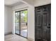 Bright room featuring a sliding glass door to the patio and modern black door, with light wood flooring at 250 Shadybrook Ln # D, Las Vegas, NV 89107