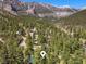 Expansive aerial view of a mountain community nestled amidst towering mountains and abundant trees at 274 Ski Trail Rd, Mount Charleston, NV 89124