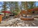 Secluded backyard featuring stone patio with firepit, outdoor dining under a red umbrella and a covered hot tub at 274 Ski Trail Rd, Mount Charleston, NV 89124