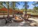 Backyard firepit area with stone patio, offering cozy seating surrounded by mature trees and landscaping at 274 Ski Trail Rd, Mount Charleston, NV 89124