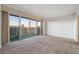 Bright living room featuring carpet floors and a large sliding glass door showcasing city views at 3111 Bel Air Dr # 12E, Las Vegas, NV 89109