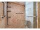 Shower with beautiful brown tile, glass door, grab bars, and convenient shelving at 3111 Bel Air Dr # 12E, Las Vegas, NV 89109