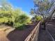 Large backyard bordered by an iron fence and mature trees, offers privacy and scenic views at 3388 Old Course St, Las Vegas, NV 89122
