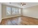Neutral bedroom with wood-look floors, ceiling fan, and multiple windows with shutters at 3618 Auckland Castle St, Las Vegas, NV 89135