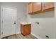 Functional laundry room with a sink, wooden cabinets, and a utility closet at 3618 Auckland Castle St, Las Vegas, NV 89135