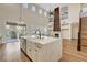 Open floor plan kitchen with large quartz island, seamlessly transitions to living area with fireplace feature at 3618 Auckland Castle St, Las Vegas, NV 89135