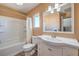 Bright bathroom features a tub with shower, toilet, and white vanity with storage and large mirror at 3708 Calumet Farm Cir, North Las Vegas, NV 89031