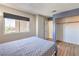 Cozy bedroom featuring wood floors, neutral walls, window with blinds, closet, and an ensuite bathroom at 3708 Calumet Farm Cir, North Las Vegas, NV 89031