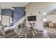 Stylish living room showcasing high ceilings, herringbone floors, and an open layout with a staircase at 3708 Calumet Farm Cir, North Las Vegas, NV 89031