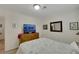 A cute bedroom with a TV, dresser, tan walls, tiled floors, and a full sized bed at 4128 Tarkin Ave, Las Vegas, NV 89120