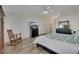 A spacious bedroom with an armoire, rocking chair, television, ceiling fan and tiled flooring at 4128 Tarkin Ave, Las Vegas, NV 89120