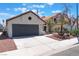 Charming single-story home featuring a terracotta roof, gray garage door, and desert landscaping at 4149 Compass Rose Way, Las Vegas, NV 89108