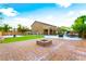 Spacious backyard featuring a brick patio, fire pit, green lawn, and a basketball court at 4200 Scott Peak Ct, Las Vegas, NV 89129