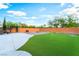 Wide shot of a backyard featuring a grassy lawn, fire pit, and brick patio at 4200 Scott Peak Ct, Las Vegas, NV 89129
