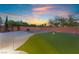 Well-manicured backyard featuring a putting green, fire pit, lush greenery, and ample space at 4200 Scott Peak Ct, Las Vegas, NV 89129