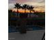 Balcony with wrought iron railing and planter offers sunset views over pool and palms at 4200 Scott Peak Ct, Las Vegas, NV 89129