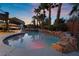 Beautiful in-ground pool features a rock waterfall, spa, and basketball hoop; great for entertaining at 4200 Scott Peak Ct, Las Vegas, NV 89129