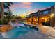 Backyard pool and jacuzzi with beautiful rock features and ample lounge space, as well as an upper level balcony at 4200 Scott Peak Ct, Las Vegas, NV 89129