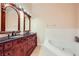 Bathroom with double vanity, ornate wood cabinetry, and large soaking tub at 440 N Lisbon St, Henderson, NV 89015
