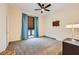 Comfortable bedroom with ceiling fan, neutral carpet, and window with curtains at 440 N Lisbon St, Henderson, NV 89015