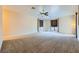 Spacious bedroom with neutral carpet, ceiling fan, and large windows with custom window treatments at 440 N Lisbon St, Henderson, NV 89015