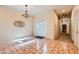 Bright entryway features tile flooring, a chandelier, and a view into the home's hallway at 440 N Lisbon St, Henderson, NV 89015