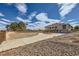 Spacious front yard featuring a circular driveway and mature trees, under a cloudy sky at 440 N Lisbon St, Henderson, NV 89015