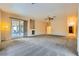 Large living room with sliding glass doors to the patio, neutral carpet, and ceiling fan at 440 N Lisbon St, Henderson, NV 89015