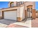 Close up of charming home featuring a tile roof, neutral stucco, and an attached two-car garage at 4514 Calico Cliff Ct, North Las Vegas, NV 89031