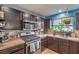 Functional kitchen with stainless steel appliances, dark cabinets, and a view of the greenery outside at 4514 Calico Cliff Ct, North Las Vegas, NV 89031