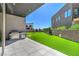Well-manicured backyard with lush artificial grass, a built-in grill, and a paved patio, offering a low-maintenance outdoor space at 5429 Succulent Rose Dr, Las Vegas, NV 89135