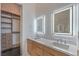 Modern bathroom with walk in closet, dual sinks, and illuminated mirrors at 5429 Succulent Rose Dr, Las Vegas, NV 89135