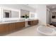 Modern bathroom features dual sinks, quartz counters, tub, and LED mirrors at 5429 Succulent Rose Dr, Las Vegas, NV 89135