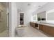 Bright bathroom features dual sinks, stylish wood cabinets, tub, and shower at 5429 Succulent Rose Dr, Las Vegas, NV 89135