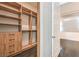 Walk-in closet with custom wood shelving and drawers adjacent to a bright room at 5429 Succulent Rose Dr, Las Vegas, NV 89135