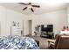Bright bedroom featuring a ceiling fan, a television, and a comfortable chair with a floral comforter at 5633 Alitak Bay St, North Las Vegas, NV 89081