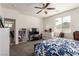 Bright bedroom featuring a ceiling fan, a television, and a large window with a floral comforter at 5633 Alitak Bay St, North Las Vegas, NV 89081