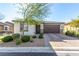 Charming single-story home showcasing a well-manicured lawn and a two-car garage, complete with stone accents and desert landscaping at 5633 Alitak Bay St, North Las Vegas, NV 89081