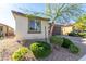 Charming single-story home showcasing a well-manicured lawn and a two-car garage, complete with stone accents and desert landscaping at 5633 Alitak Bay St, North Las Vegas, NV 89081