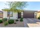 Charming single-story home showcasing a well-manicured lawn and a two-car garage, complete with stone accents and desert landscaping at 5633 Alitak Bay St, North Las Vegas, NV 89081