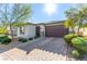 Charming single-story home showcasing a well-manicured lawn and a two-car garage, complete with stone accents and desert landscaping at 5633 Alitak Bay St, North Las Vegas, NV 89081